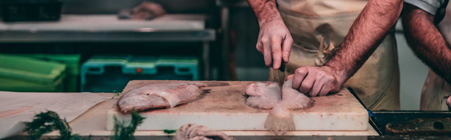 Un ristoratore mentre sfiletta un pesce